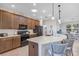 Kitchen with a large island, stainless steel appliances, and dark wood cabinetry providing abundant storage space at 3681 Arlington Ridge Blvd, Leesburg, FL 34748