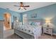 Bright main bedroom featuring a ceiling fan, en-suite bath, and carpeted floor at 3681 Arlington Ridge Blvd, Leesburg, FL 34748