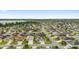 Expansive aerial shot of a peaceful community, highlighting the well-spaced homes and green spaces with the lake in the distance at 3750 Raspberry Ct, The Villages, FL 32163