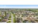 Beautiful aerial view of an expansive neighborhood with lush landscaping, palm trees, and well-maintained streets, near the lake at 3750 Raspberry Ct, The Villages, FL 32163