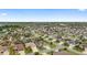 Stunning aerial view capturing a large residential community with a variety of home styles, tree-lined streets, and nearby lake at 3750 Raspberry Ct, The Villages, FL 32163