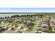Panoramic aerial view of a charming neighborhood near a lake, showcasing well-maintained homes with lush landscaping at 3750 Raspberry Ct, The Villages, FL 32163