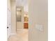 Hallway leading to bathroom with tile flooring and shower with glass block window at 3750 Raspberry Ct, The Villages, FL 32163