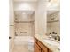 Well-lit bathroom featuring a tiled shower-tub combination and a granite-topped vanity at 3750 Raspberry Ct, The Villages, FL 32163