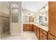Bathroom featuring double sinks, granite countertops, and a shower with glass block window at 3750 Raspberry Ct, The Villages, FL 32163
