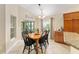 Charming dining area featuring a wooden table set, complemented by abundant natural light from large windows at 3750 Raspberry Ct, The Villages, FL 32163