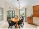 Bright dining area featuring a wooden table set, complemented by abundant natural light from large windows at 3750 Raspberry Ct, The Villages, FL 32163