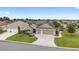 Aerial view of a well-maintained home with three-car garage, mature landscaping and a long driveway at 3750 Raspberry Ct, The Villages, FL 32163