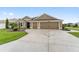 Charming one-story home featuring a well-maintained lawn, mature landscaping, and a spacious three-car garage at 3750 Raspberry Ct, The Villages, FL 32163
