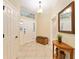Welcoming foyer featuring neutral tile, a bench, a decorative mirror, and ample natural light at 3750 Raspberry Ct, The Villages, FL 32163