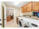 Well-equipped laundry room with cabinets, shelves, and a laundry sink conveniently located near the kitchen at 3750 Raspberry Ct, The Villages, FL 32163