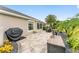 Outdoor patio area with lush landscaping, seating, and grilling area at 3750 Raspberry Ct, The Villages, FL 32163