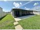 A spacious backyard features a screened-in patio and lush green lawn at 384 Summer Squall Rd, Davenport, FL 33837