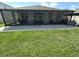 Lush green backyard features a screened-in patio and ample space for outdoor enjoyment at 384 Summer Squall Rd, Davenport, FL 33837