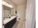 Well-lit bathroom with double sinks, a framed mirror, and stylish fixtures for a modern appeal at 384 Summer Squall Rd, Davenport, FL 33837