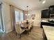Dining area featuring a modern table set, stylish lighting, and seamless access to the kitchen with stainless steel appliances at 384 Summer Squall Rd, Davenport, FL 33837