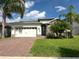 Charming home featuring a brick driveway, stone accents, well-maintained lawn and beautiful curb appeal at 384 Summer Squall Rd, Davenport, FL 33837