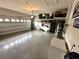 Spacious garage with epoxy floors, storage shelving, and ample space for vehicles and projects at 384 Summer Squall Rd, Davenport, FL 33837