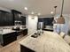 Contemporary kitchen with granite countertops, modern appliances, a large island with pendant lighting, and an open layout at 384 Summer Squall Rd, Davenport, FL 33837
