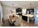 Open-concept kitchen and dining area featuring modern lighting, stainless steel appliances, and a large island at 384 Summer Squall Rd, Davenport, FL 33837