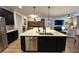 Open-concept kitchen featuring an oversized island, stainless steel appliances, modern lighting, and seamless access to the living room at 384 Summer Squall Rd, Davenport, FL 33837