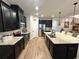 Beautiful kitchen featuring granite countertops, sleek black cabinets, stainless steel appliances and decorative pendant lighting at 384 Summer Squall Rd, Davenport, FL 33837