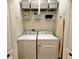 A well-organized laundry room featuring a washer, dryer, and ample shelving for storage at 384 Summer Squall Rd, Davenport, FL 33837