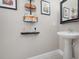 Elegant half-bathroom featuring a pedestal sink, modern faucet, and decorative wall art at 4814 Luge Ln, Orlando, FL 32839