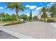 Grand gated entrance to the community with lush landscaping and mature palm trees at 4814 Luge Ln, Orlando, FL 32839