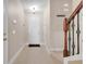 Bright foyer featuring tile floors, a staircase with decorative iron railings, and a coat rack at 4814 Luge Ln, Orlando, FL 32839