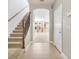 Bright foyer featuring tile floors, a staircase with decorative iron railings, and an open view to other rooms at 4814 Luge Ln, Orlando, FL 32839
