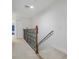 Bright hallway featuring carpeted floors, wood and iron railings, and white trim at 4814 Luge Ln, Orlando, FL 32839