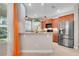 Modern kitchen featuring stainless steel appliances, a breakfast bar, and wood cabinets at 4814 Luge Ln, Orlando, FL 32839