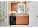 Galley kitchen with black appliances, wood cabinets, and access to the outdoors at 4814 Luge Ln, Orlando, FL 32839