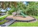 Community playground featuring a climbing wall, slide, and play structure in a wooded area at 4814 Luge Ln, Orlando, FL 32839