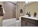 Modern bathroom features a bathtub with shower, tiled walls, and a vanity with a sink at 5177 Blanket Flower St, Apopka, FL 32712