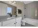 Contemporary bathroom with white cabinets, grey countertops, and a tiled shower and bathtub combo at 5177 Blanket Flower St, Apopka, FL 32712