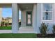View of a covered entryway with a blue front door and fresh landscaping at 5177 Blanket Flower St, Apopka, FL 32712