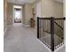 Carpeted hallway with dark wood railing, connecting various rooms in the house at 5177 Blanket Flower St, Apopka, FL 32712