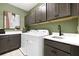 Well-equipped laundry room with modern washer and dryer, custom cabinets and stylish decor at 5177 Blanket Flower St, Apopka, FL 32712