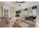 Upstairs living room looking into the kitchen featuring modern neutral furnishings and lots of light at 5177 Blanket Flower St, Apopka, FL 32712