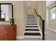 Stairway featuring carpeted steps, dark wood handrail, and views of the home's interior at 5177 Blanket Flower St, Apopka, FL 32712