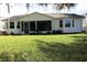 Backyard with lawn, bushes and enclosed Lanai at 651 Timbercrest Dr, Leesburg, FL 34748