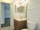 Bathroom featuring a light wood vanity and mirrored medicine cabinet at 651 Timbercrest Dr, Leesburg, FL 34748