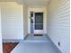 Covered front porch with updated grey flooring and white vinyl siding for a clean, welcoming entryway at 651 Timbercrest Dr, Leesburg, FL 34748