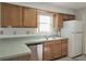 Functional kitchen features wood cabinets, double sink, and modern dishwasher appliance at 651 Timbercrest Dr, Leesburg, FL 34748