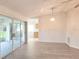Living room with neutral walls, gray laminate flooring, and sliding door access to lanai at 651 Timbercrest Dr, Leesburg, FL 34748