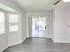 Spacious room with gray flooring and sliding glass door to screened patio at 651 Timbercrest Dr, Leesburg, FL 34748