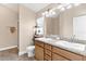Bathroom featuring double sinks, a shower with glass door, and a large mirror at 7732 Sloewood Dr, Leesburg, FL 34748