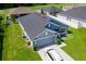 Angle view of single-story house with blue exterior, gray roof, and two-car garage at 7732 Sloewood Dr, Leesburg, FL 34748